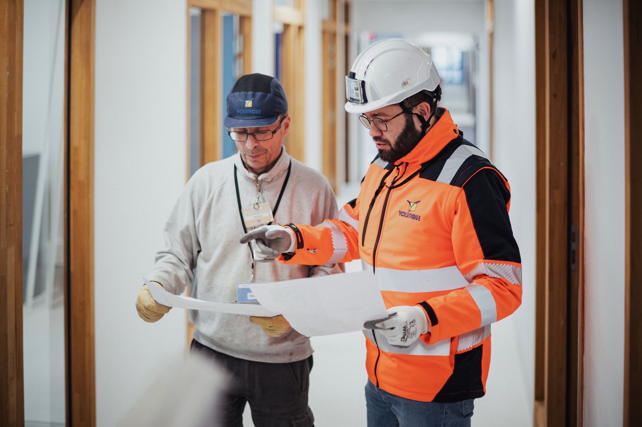 2 collaborateurs Volutique analysant des plan sur un chantier pour du réaménagement intérieur.